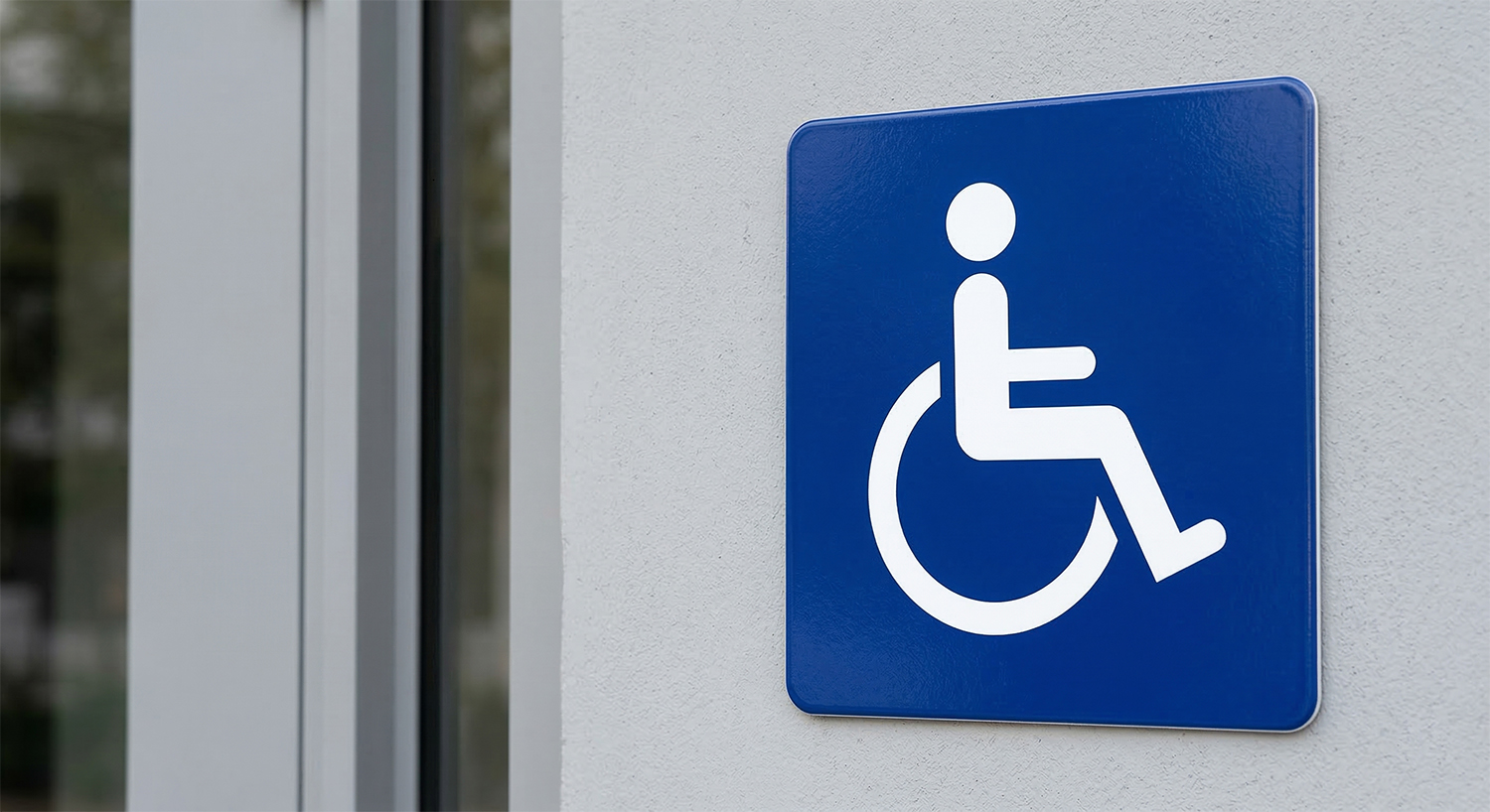 Mavi kare tabela üzerinde, tekerlekli sandalyeyi aktif olarak kullanan ve hareket halinde olan beyaz renkli dinamik figür (Aktif ISA sembolü).